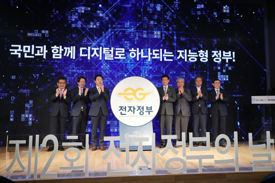문용식 한국정보화진흥원장(왼쪽 첫번째), 진영 행안부 장관(네번째, 안문석 전자정부추진위원장(다섯번째) 등 인사들이 24일 서울 광화문 KT스퀘어에서 열린 '제2회 전자정부의 날' 기념식에서 지능형 정부 비전을 선포하고 있다.  행안부 제공